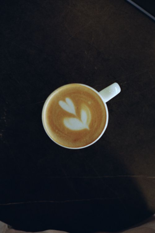 Free Top view of a cup of latte with heart-shaped foam art, perfect for coffee lovers. Stock Photo