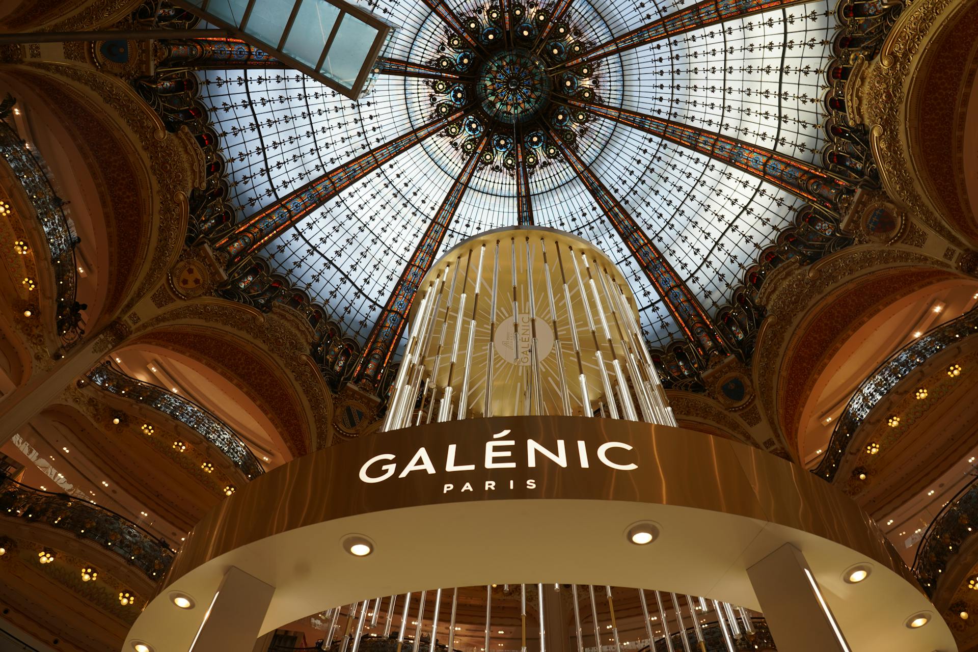 Ornate interior dome of Galeries Lafayette in Paris, showcasing luxury and architectural beauty.