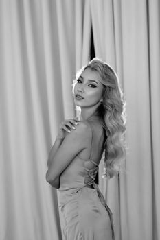Sophisticated portrait of a woman in a black and white dress with flowing blonde hair.