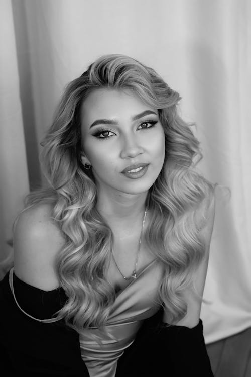 A woman with long hair posing for a black and white photo