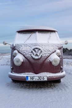 A classic Volkswagen van covered in snow on a winter day in Kampen, Sylt.