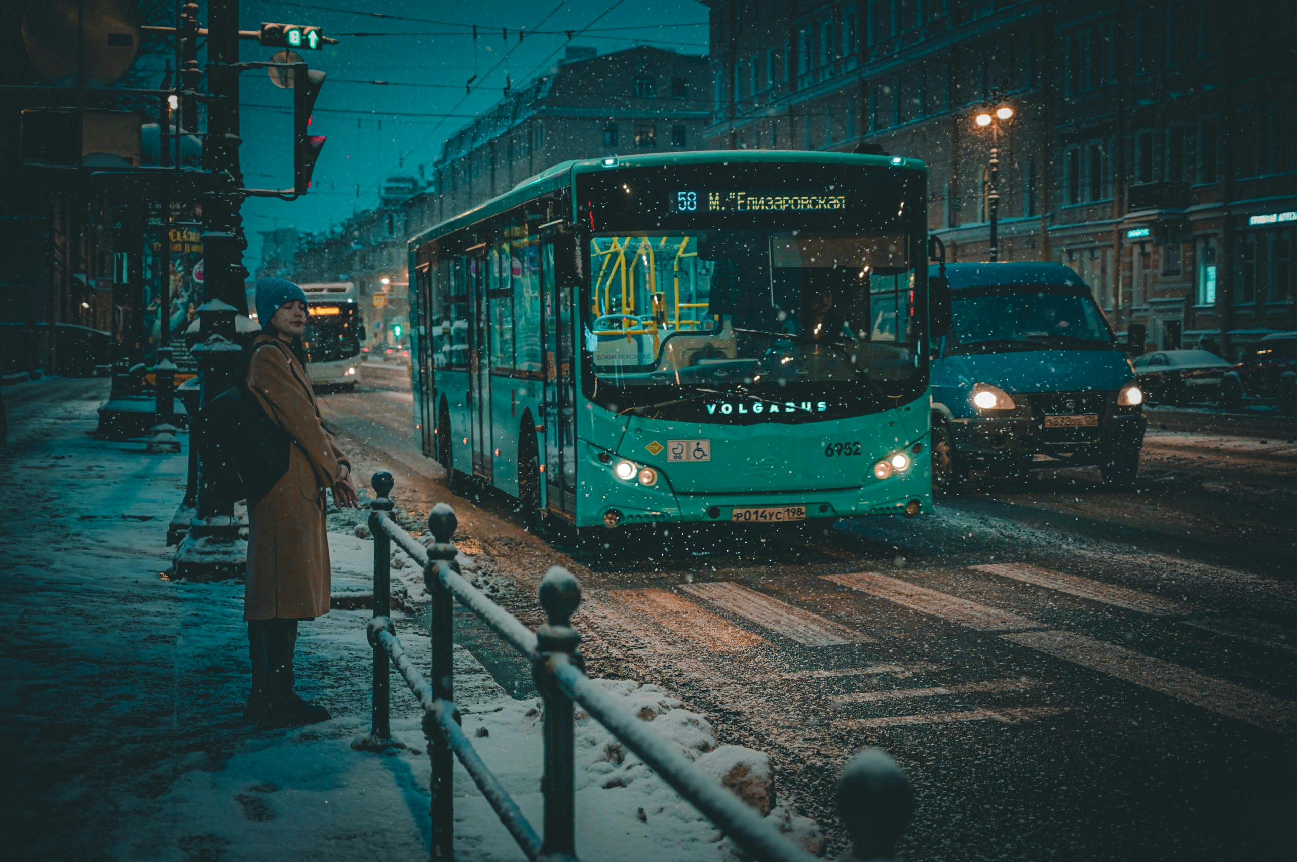City street in St. Petersburg capturing a public bus during a snowy winter night.