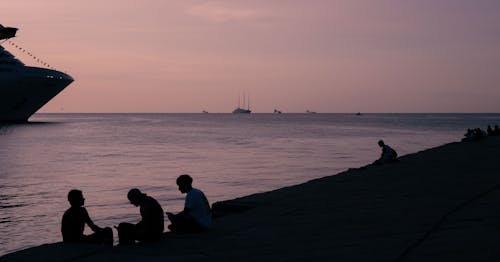 Men Sit on Promenade at Dawn