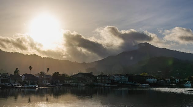 Beautiful sunrise over a bay town with mountains and houses in the background.