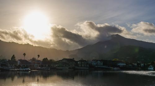 Free Beautiful sunrise over a bay town with mountains and houses in the background. Stock Photo