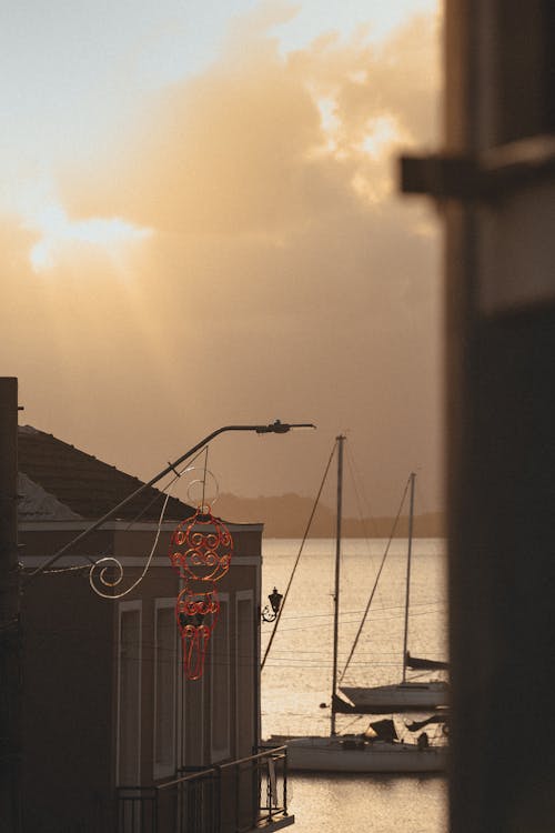 Sailboats Moored behind Building at Sunset