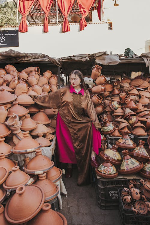 Woman in Traditional Clothing among Traditional Pots