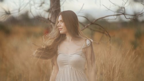 Free A woman in a white dress enjoys the calm of a rural field. Stock Photo