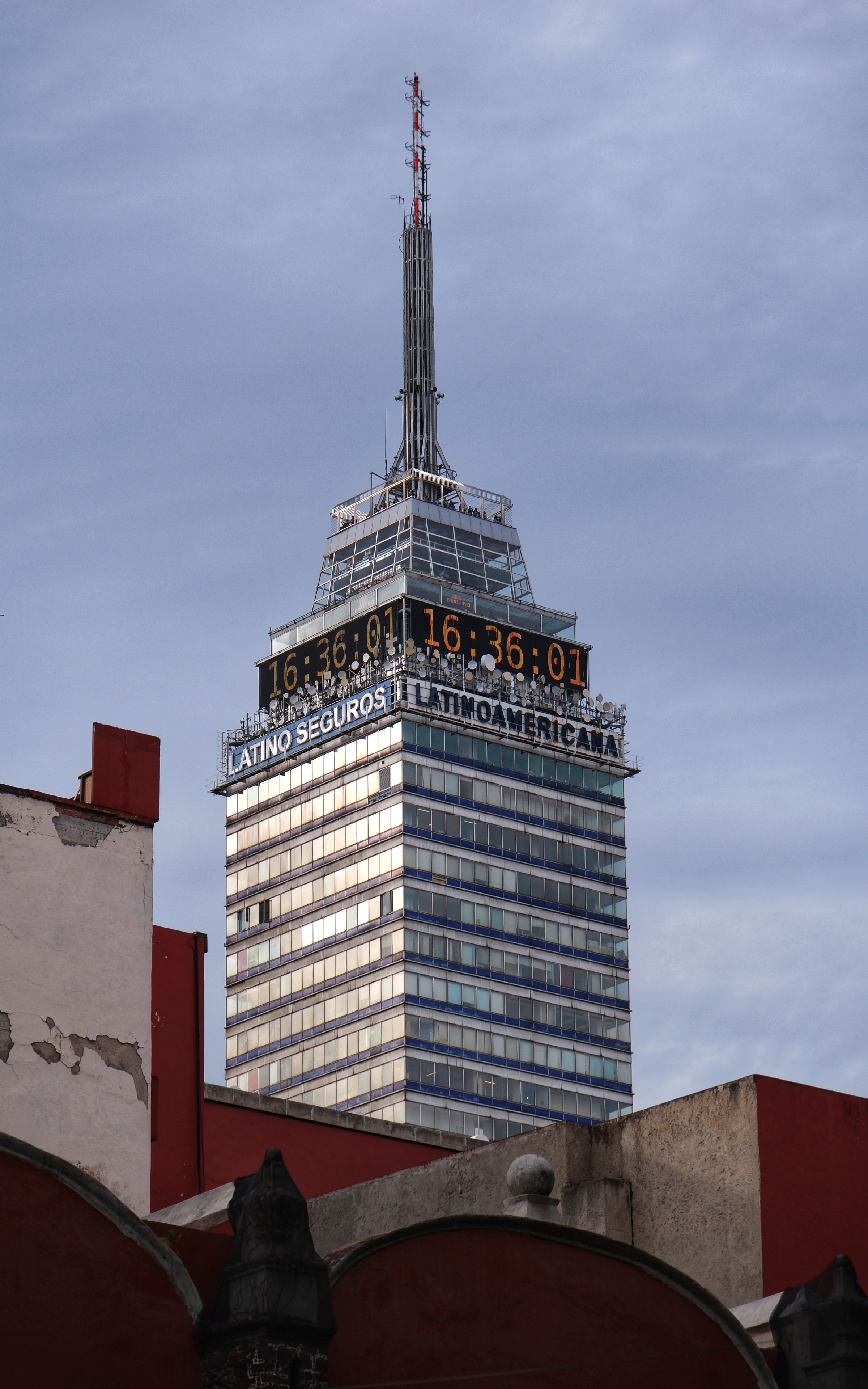 Iconic Torre Latinoamericana skyscraper in Mexico City against a cloudy sky.