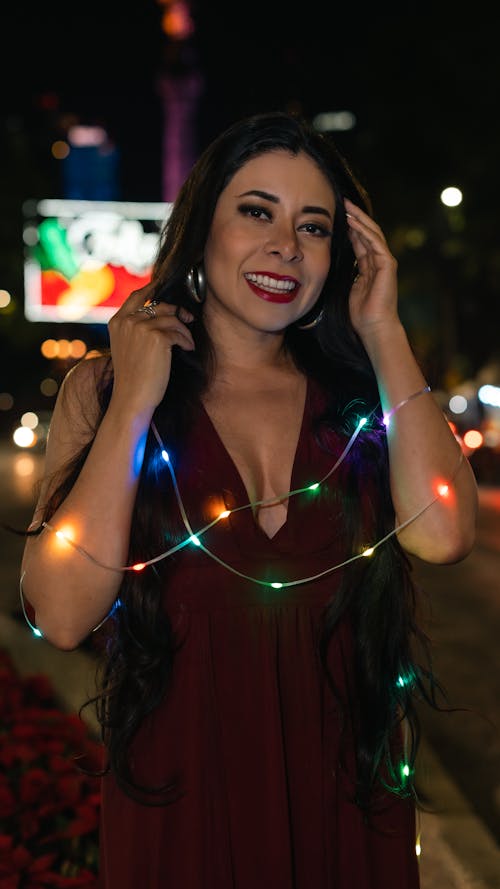 Brunette Woman in Red Dress and with Christmas Lights