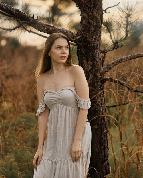 Woman in White Dress Standing by Field