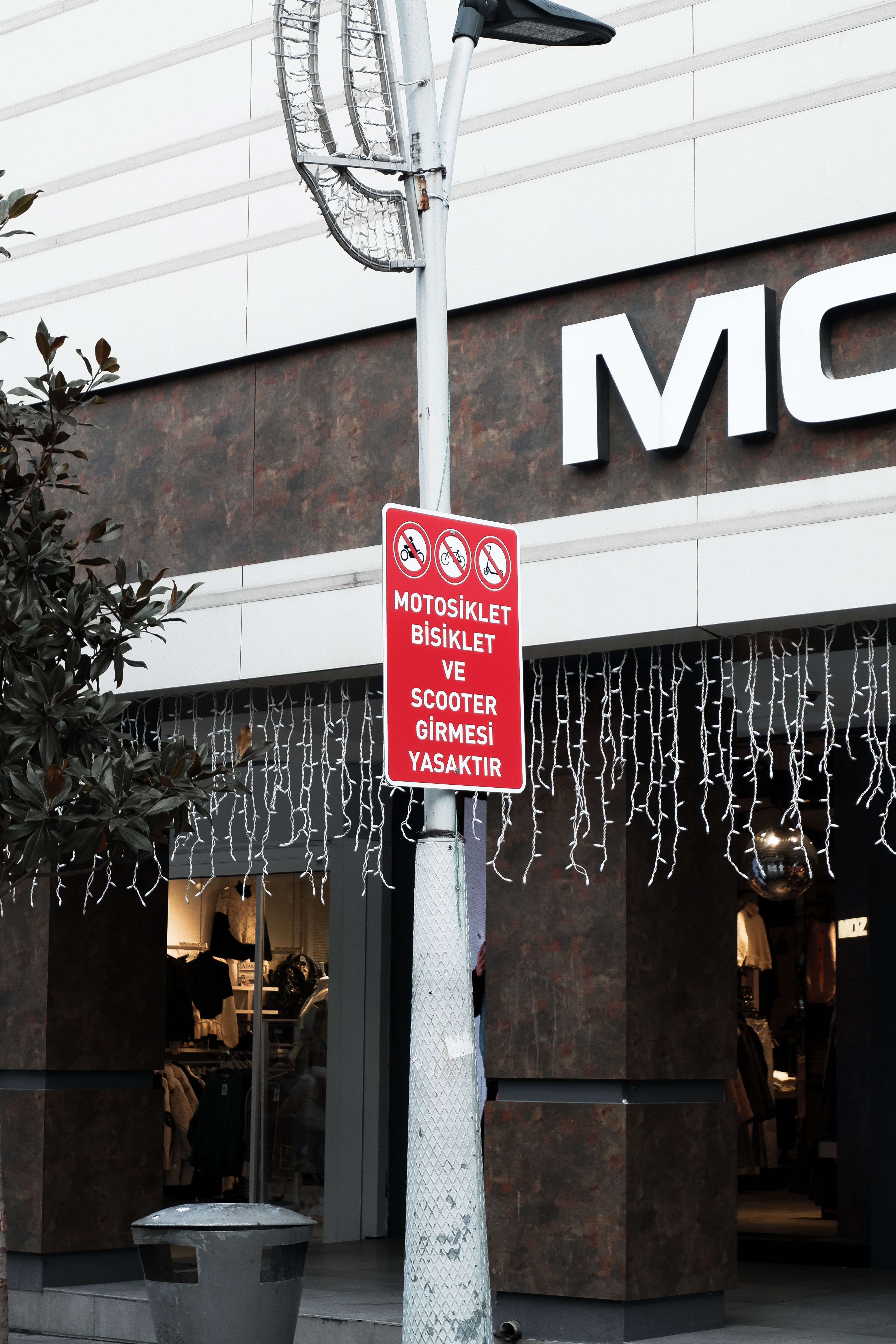 Street scene featuring a red prohibition sign against scooters and motorcycles.