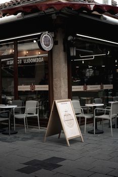 Charming urban café exterior with seating and a sidewalk sign in a quaint town corner.