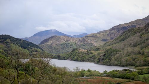 Free Tranquil view of a lake surrounded by lush hills and mountains in spring. Stock Photo