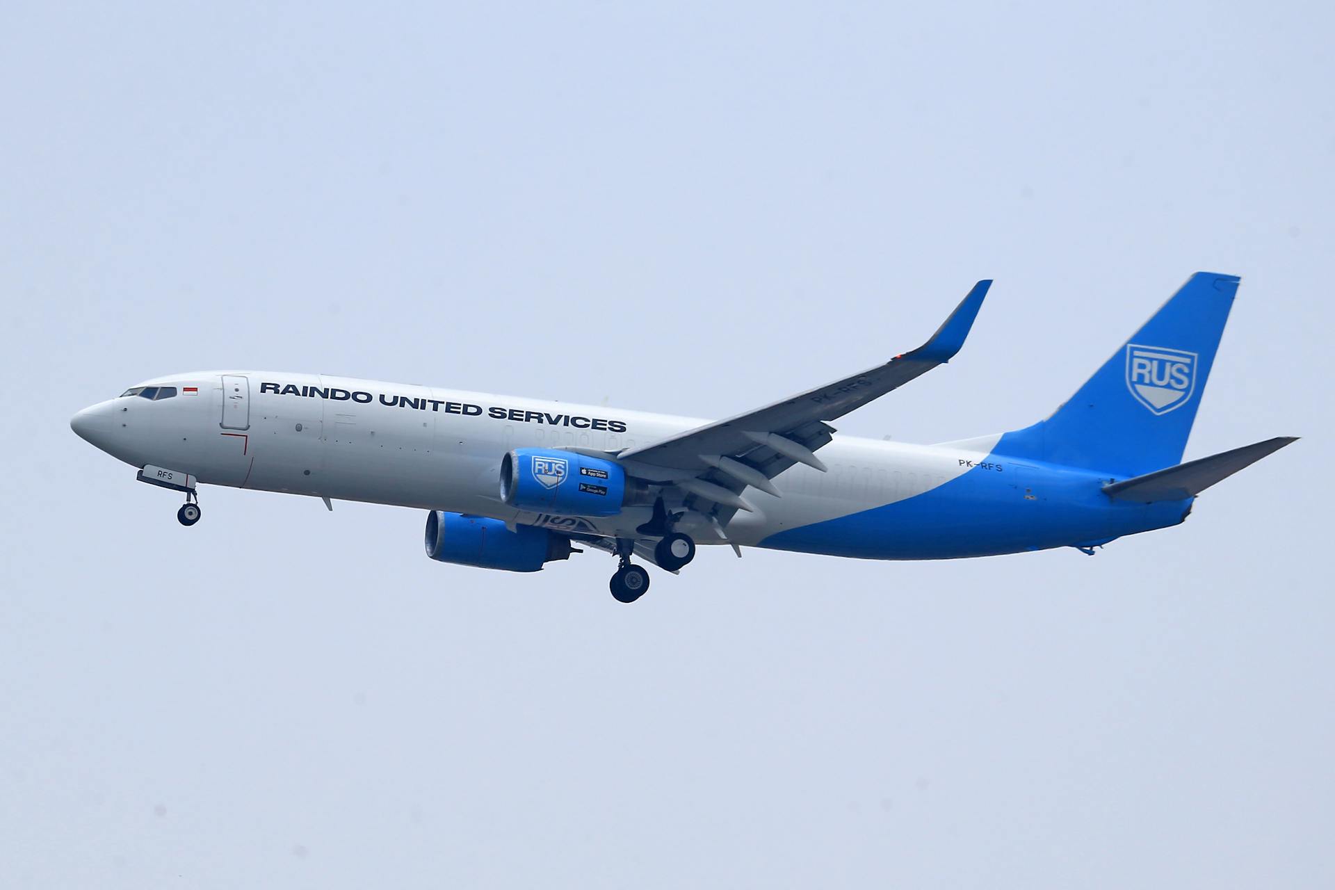 Side view of a Raindo United Services Boeing 737 cargo plane in mid-flight.