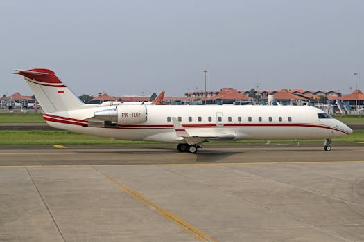 Private Bombardier Challenger 850 jet taxiing on runway in daytime.