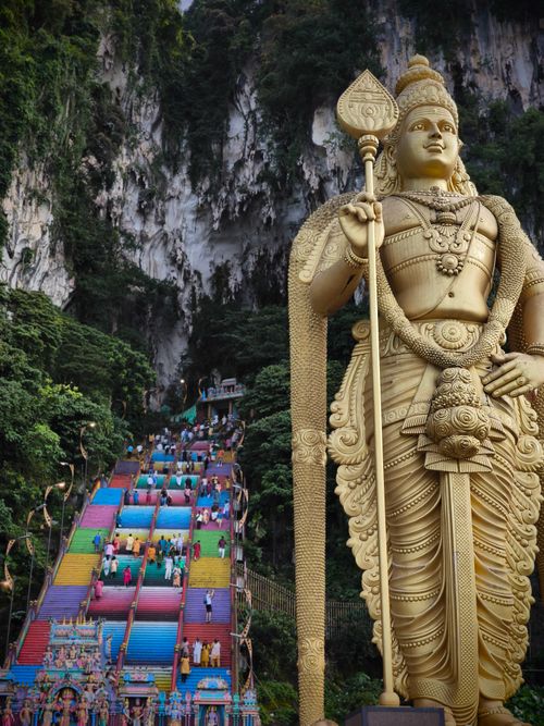 Free Iconic golden statue and vibrant stairway leading to Batu Caves in Malaysia. Stock Photo