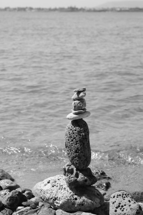 Free Peaceful stacked stones on a Sicilian beach in black and white. Stock Photo