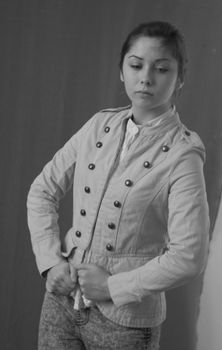 Elegant portrait of a woman posing indoors in a military-style jacket.