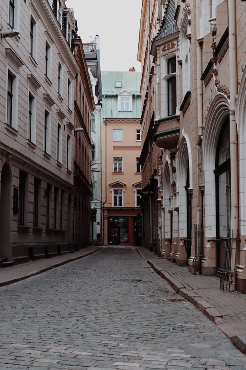 Free Empty cobblestone street between historic buildings in Riga's Old Town, Latvia. Stock Photo