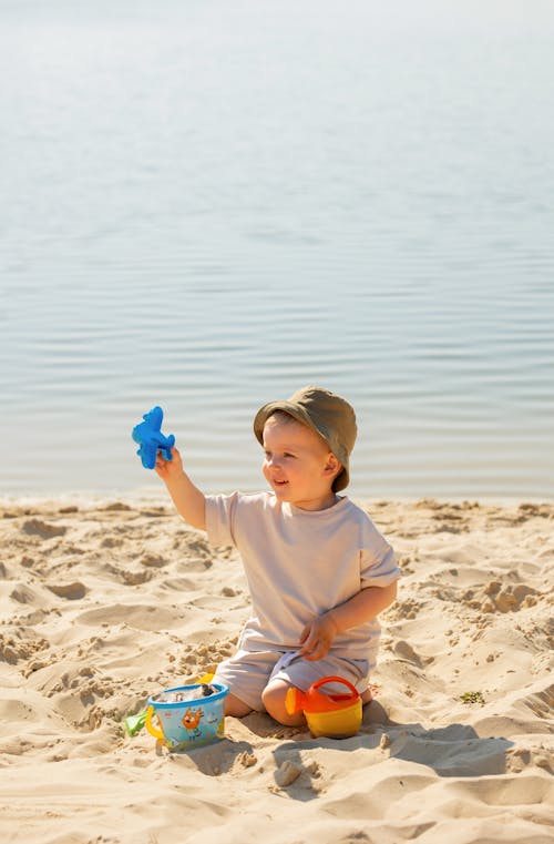 Boy Plating Toy Airplane on Beach
