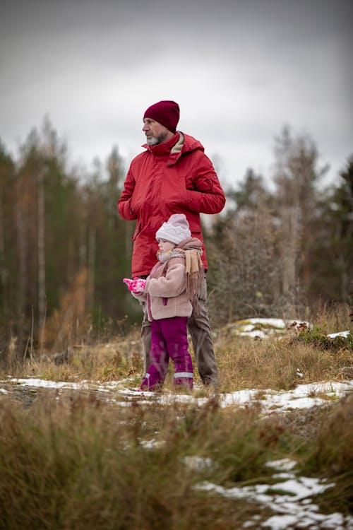 Father in Red Jacket Standing with Daughter in Winter