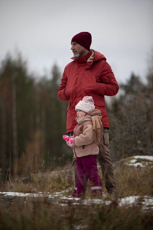 Free A man and child enjoy a winter walk in a scenic field. Stock Photo