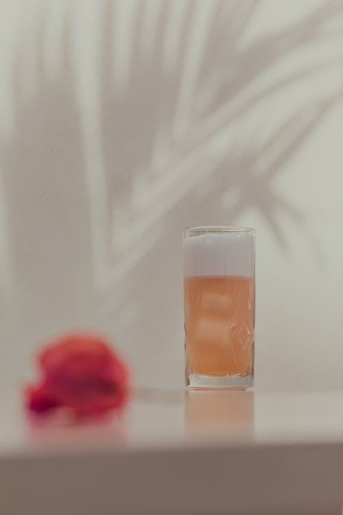 Glass of Beverage behind Flower
