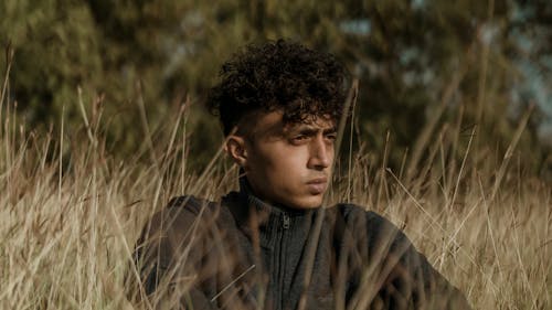 Man Sitting among Grasses