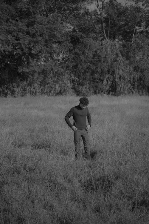 Man Looking Down on Grassland