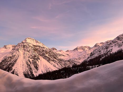 Magnificent snowy Alps at sunrise in Arosa, Switzerland, showcasing serene winter beauty.