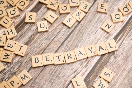 The word betrayal spelled out in scrabble tiles
