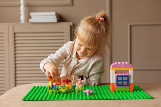 Young girl engaged in building with colorful blocks. Indoor creative activity.