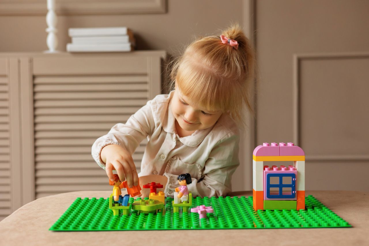 young girl engaged in building with colorful blocks indoor creative ac