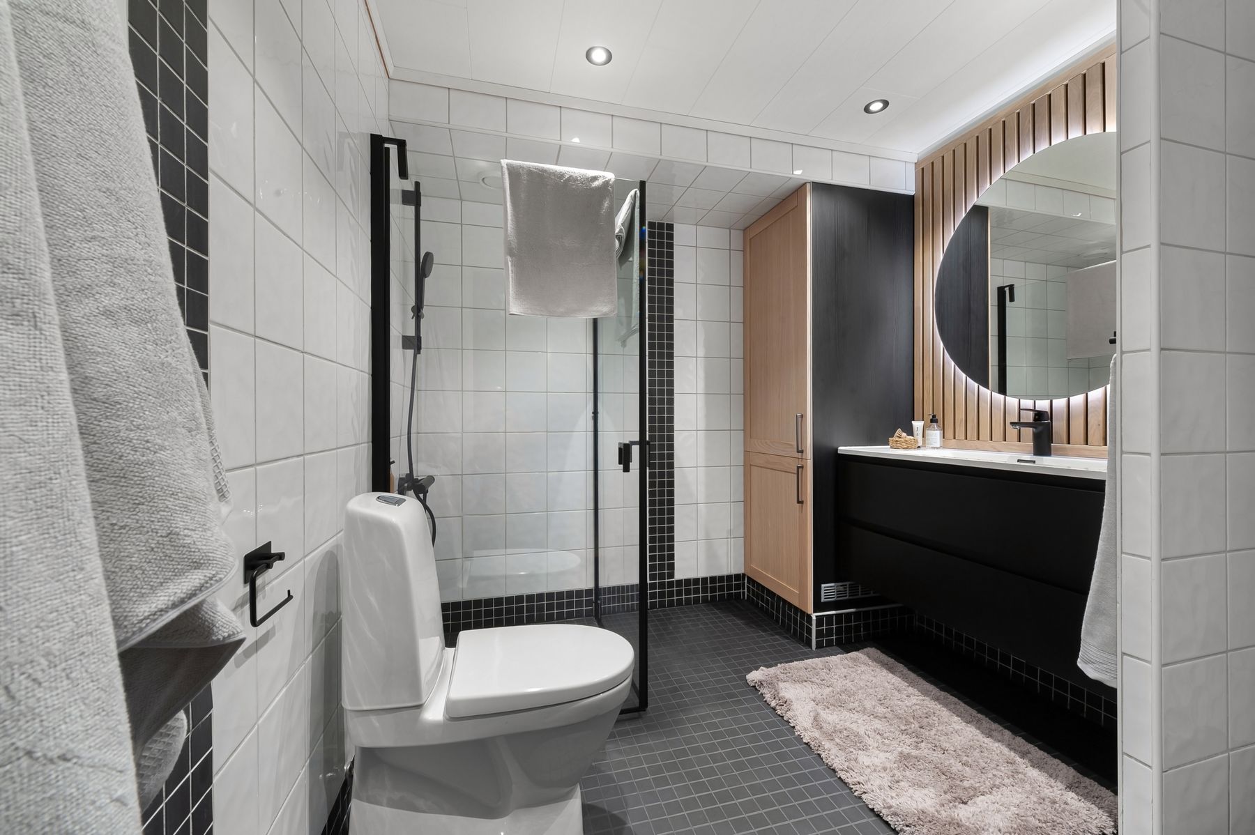 Black and white tiled bathroom with visible grout grid and modern fixtures