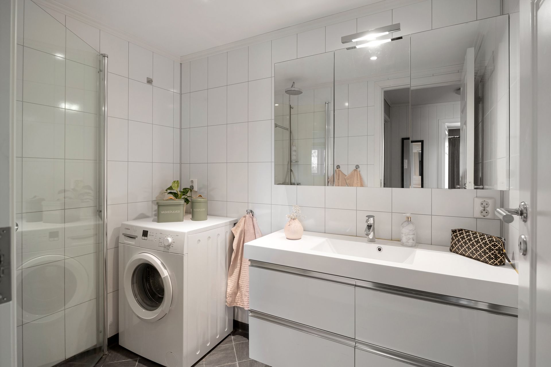 Stylish bathroom featuring a washing machine and sleek interior design elements.