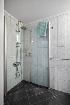 Sleek glass shower enclosure in a contemporary bathroom featuring white tiles and modern fixtures.
