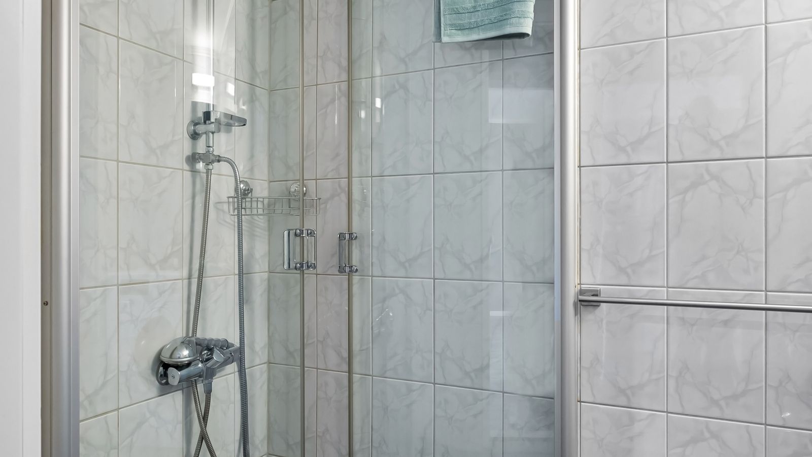 A modern tiled shower with a rainfall shower head