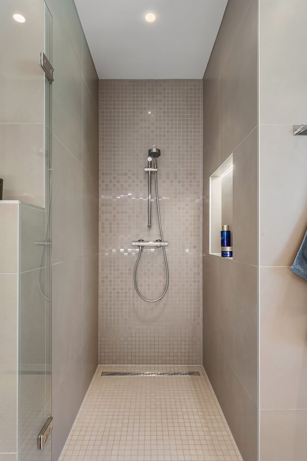 Shower inspiration with frameless glass, gray tile, a recessed niche and chrome fixtures