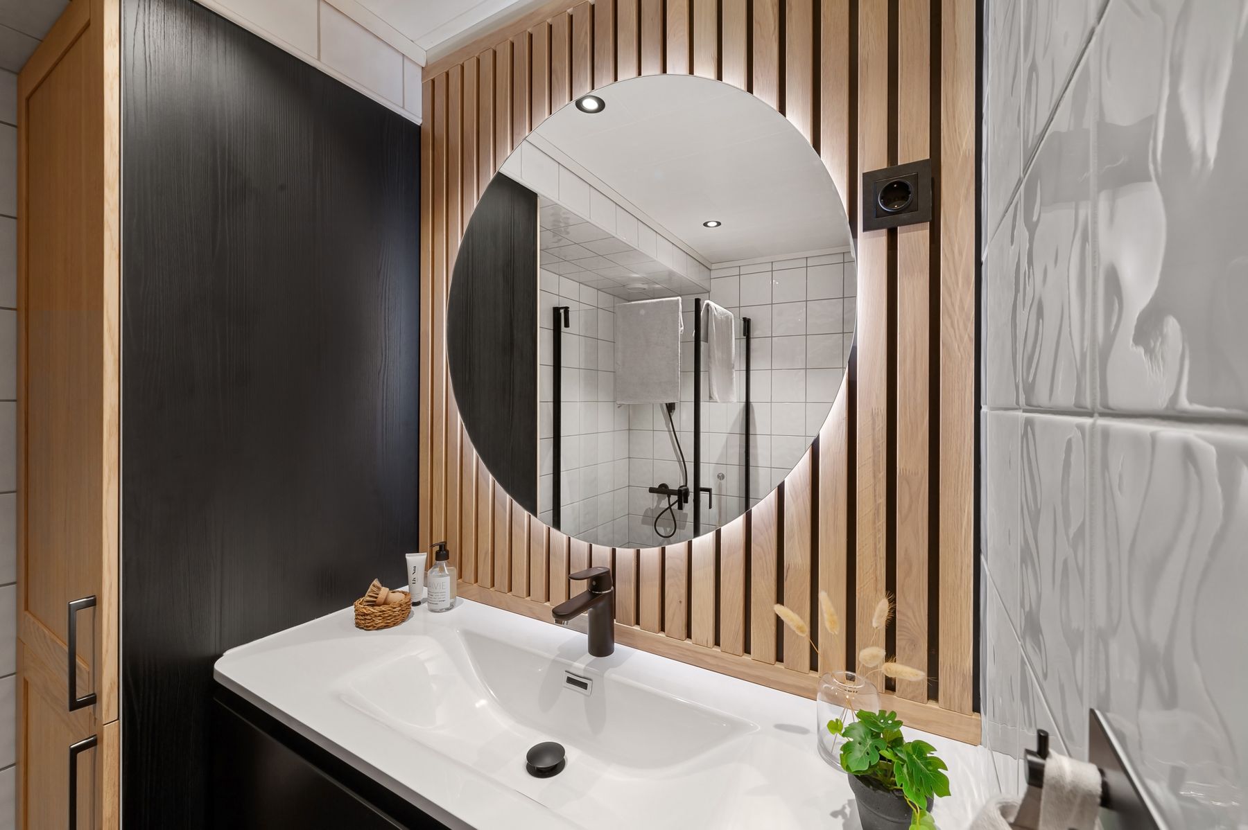 Calm bathroom vanity with round mirror and integrated light