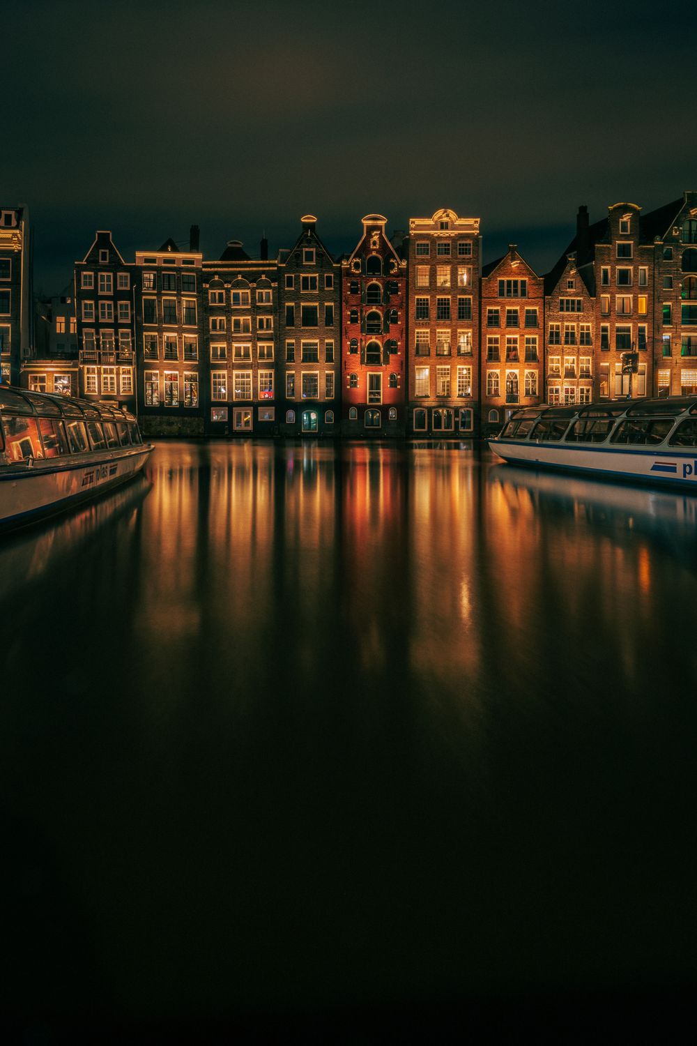 Verlichte gracht in de avond