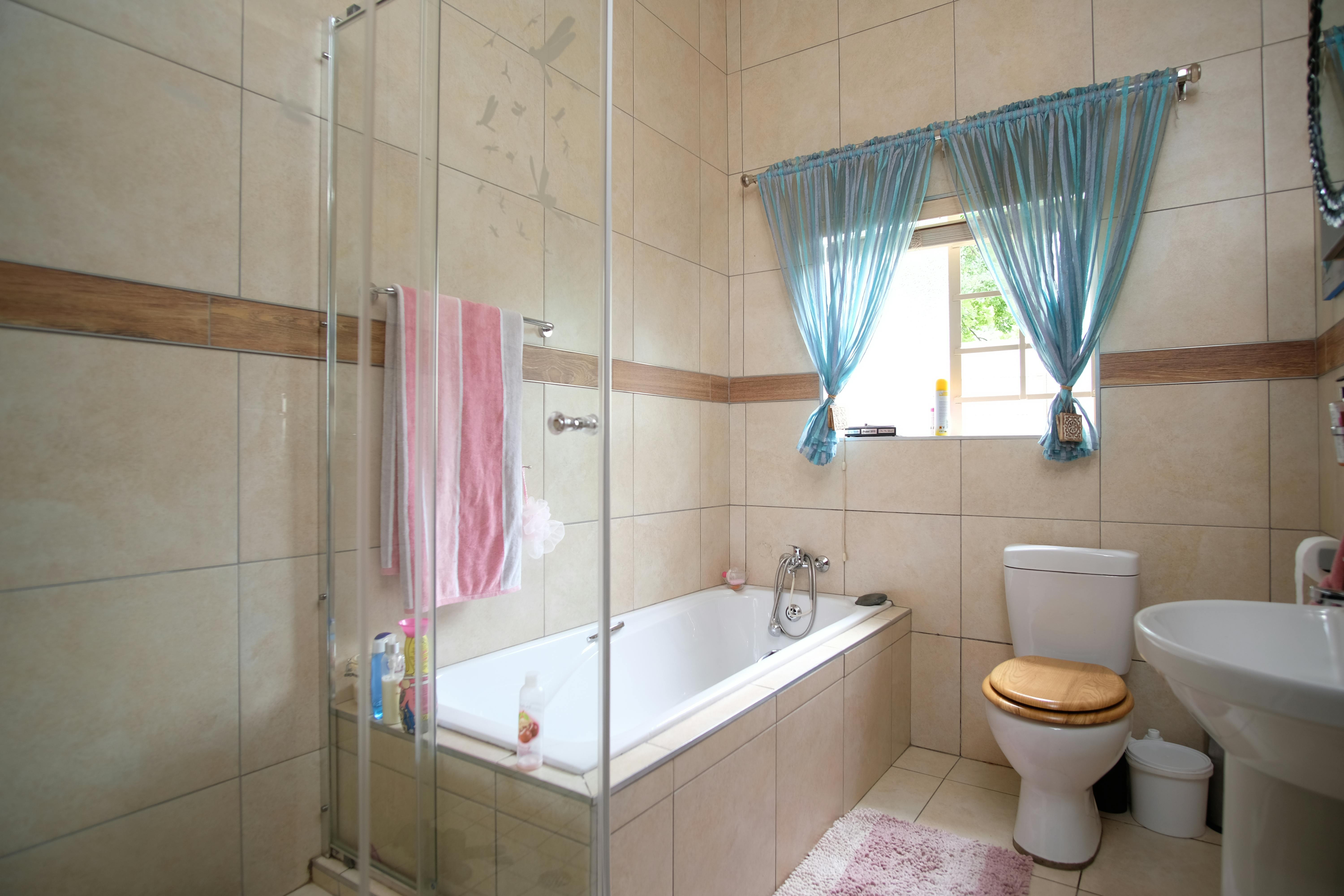 Bad mit geöffneter Tür und beschlagfreiem Spiegel nach Stoßlüften, Handtücher ordentlich aufgehängt