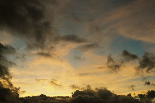 Free A picturesque sunset with dramatic clouds in a colorful sky. Stock Photo