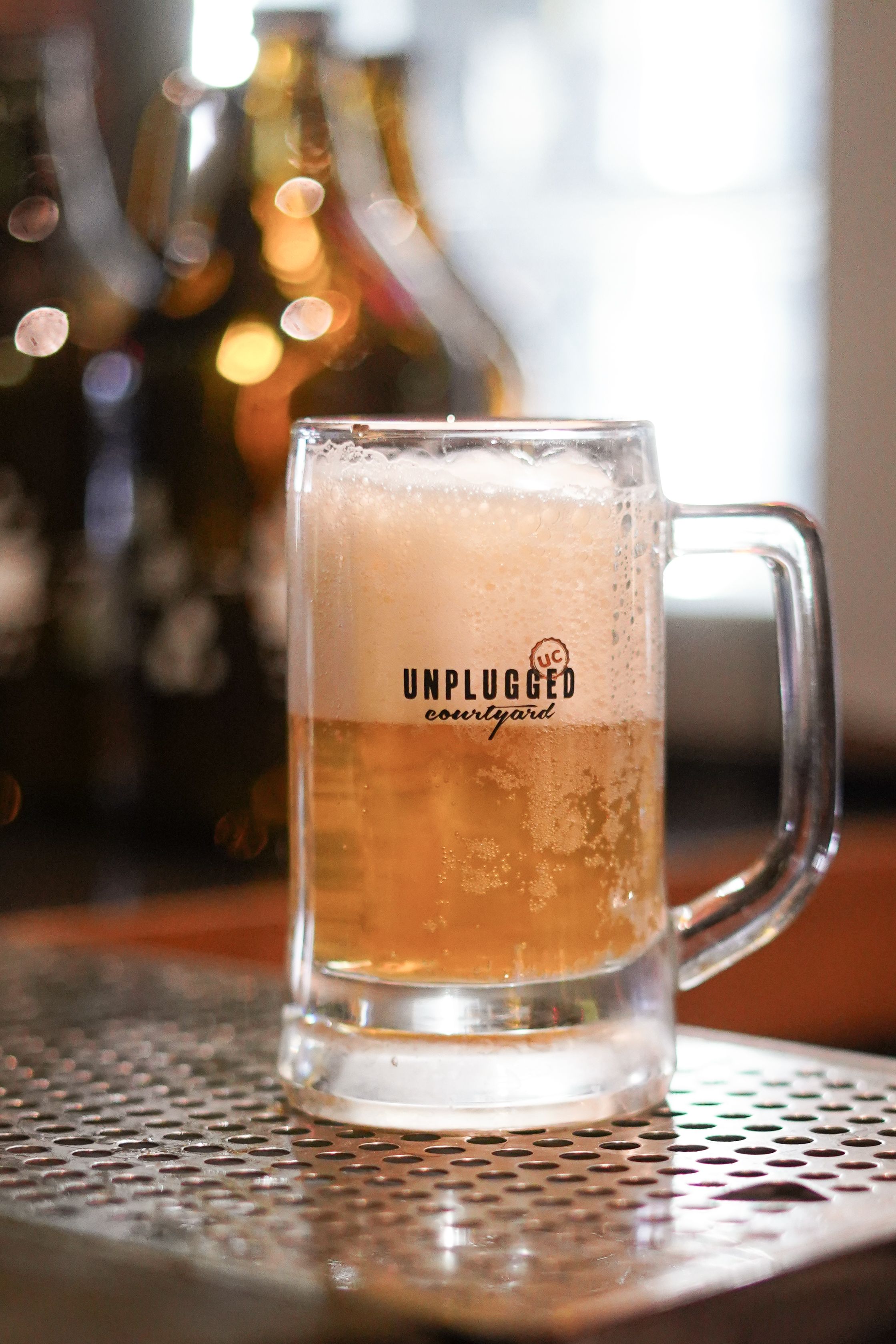 Chilled beer mug with foam at Unplugged bar, capturing a refreshing moment indoors.