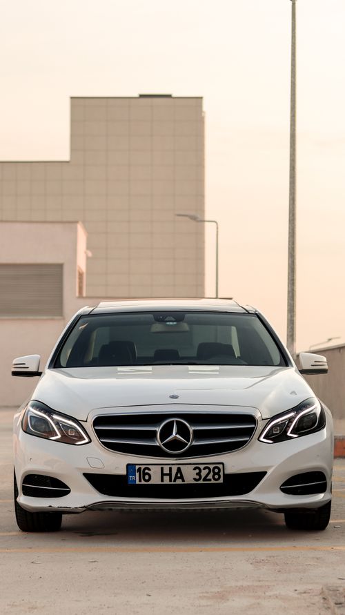 Free White luxury car parked in an urban area, showcasing modern design and elegance. Stock Photo