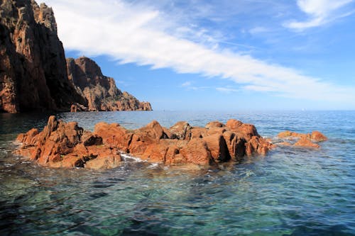 A rocky shoreline with a blue sky and water