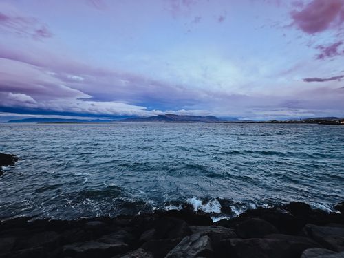 Free Breathtaking dusk scene of Reykjavík coastline with dramatic skies and sea view. Stock Photo
