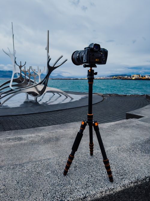 Free A camera on a tripod capturing the Sun Voyager sculpture in Reykjavík, Iceland. Stock Photo