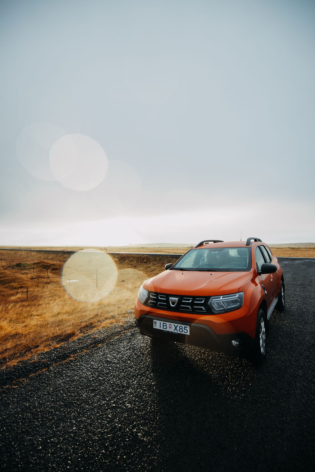 Orange SUV on an open scenic road