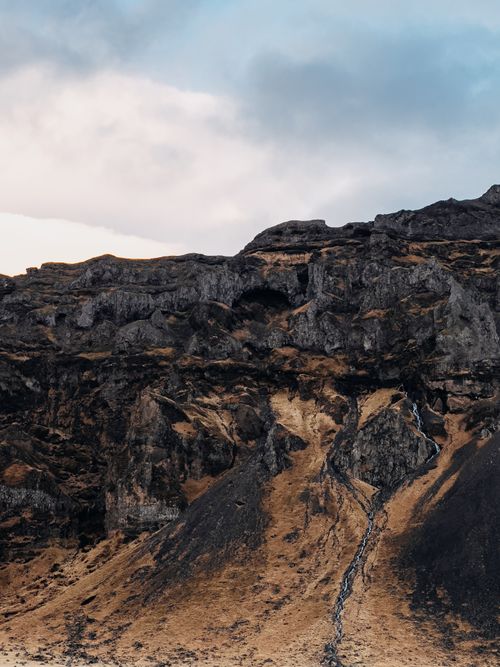 Free Stunning view of a rocky cliff and cascading waterfall in Rangárþing eystra, Iceland. Stock Photo